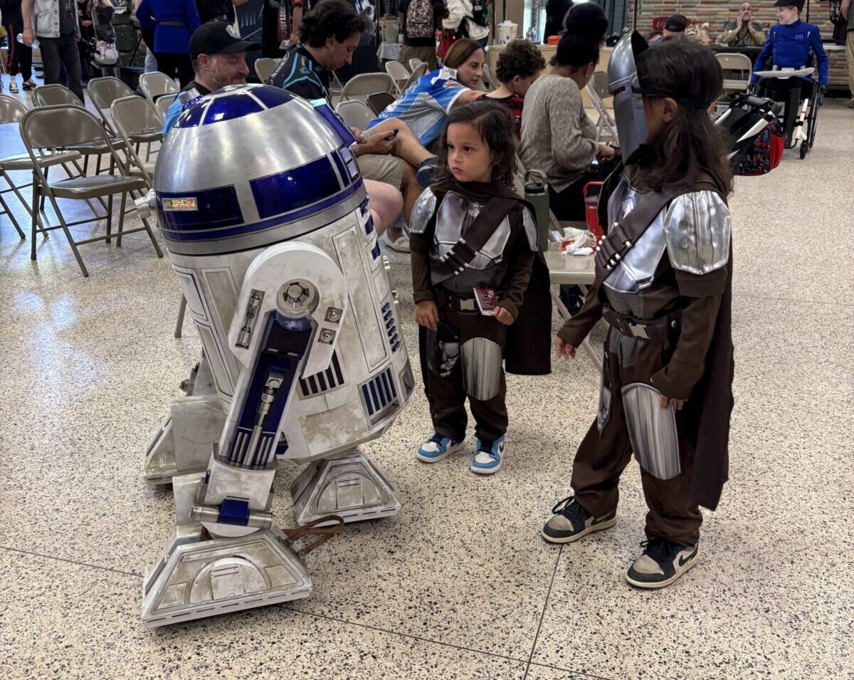 R2D2 and a kids dressed as the Mandalorian at Troopercon