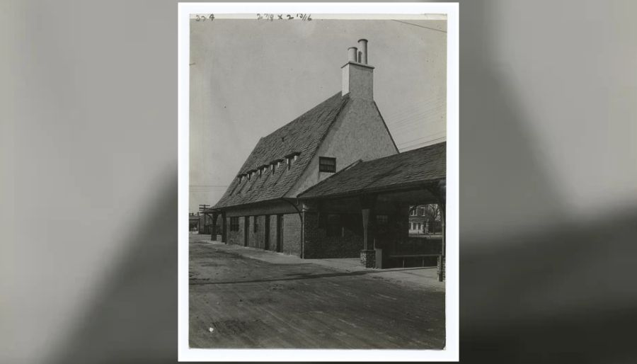 Historic photograph of Baldwin's 1917 Long Island Rail Road station, featuring a steeply pitched roof, dormer windows, brick walls and a covered entrance.